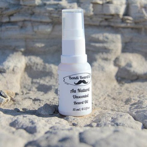 Image of Bondi Beard Co. Au Naturel Beard Oil in white spray bottle sitting on natural sandstone surface outside.