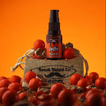 Load image into Gallery viewer, Image of Bondi Beard Co. Jaffa Beard Oil spray bottle, sitting on branded hessian bag, and surrounded by chocolate orange confectionery, with bright orange background.
